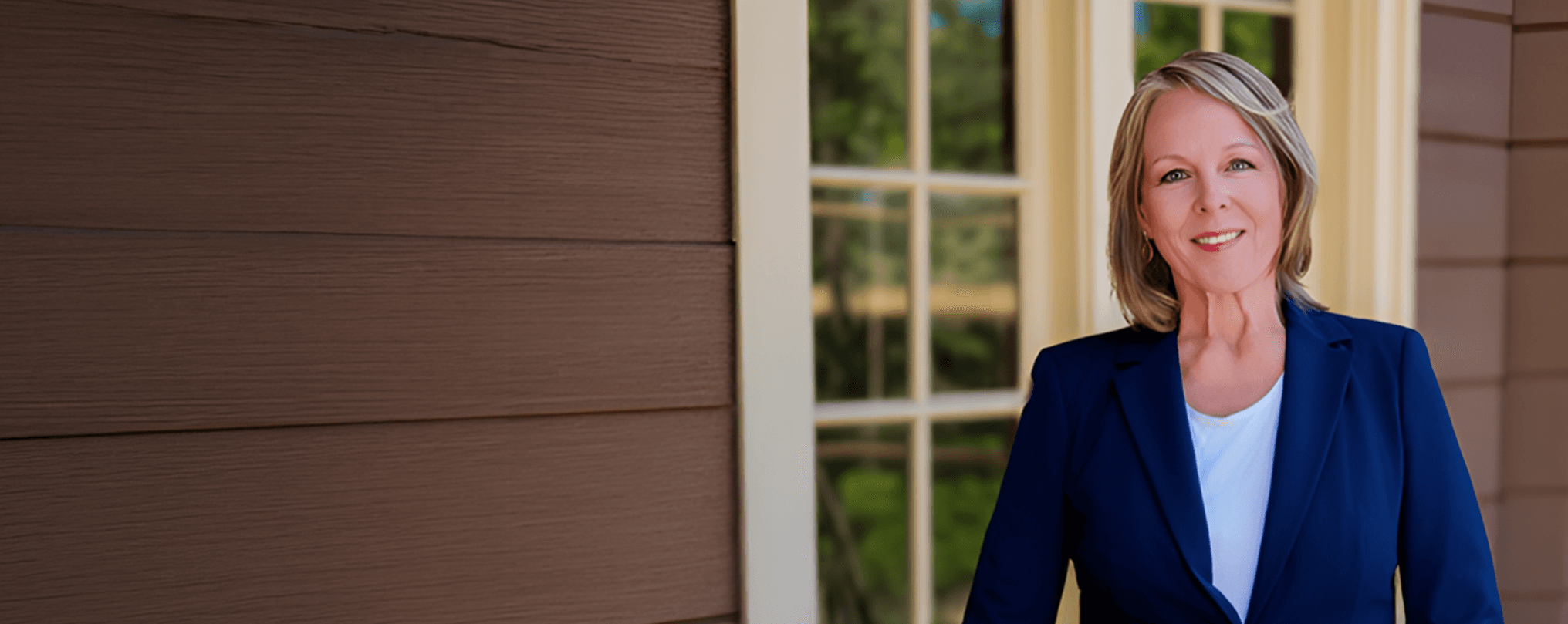Dr. Barbara Kahl on a porch with American flag and Mt. Hood in background